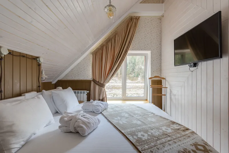 Chambre de location sous combles, lit fait avec serviettes pliées