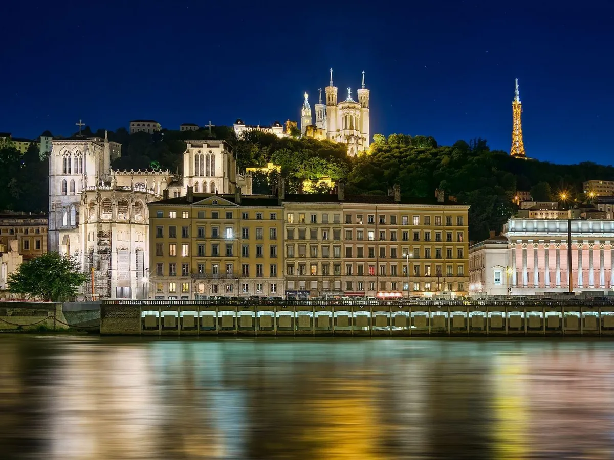 La colline de Fourvière et sa basilique illuminées au-dessus de la Saône, à Lyon, de nuit